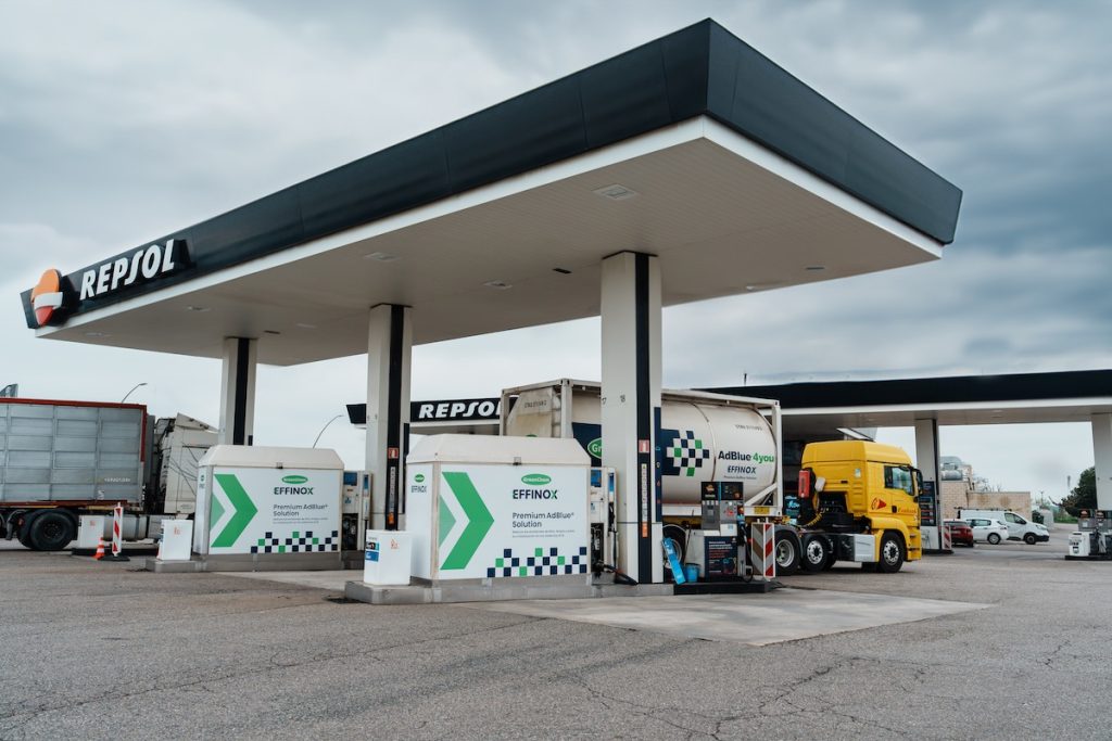 Estación de servicio Repsol con camiones y surtidores.