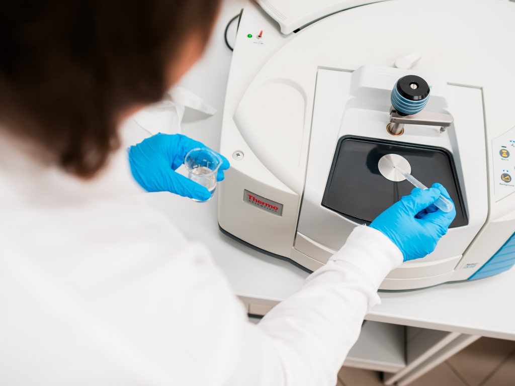 Scientist using laboratory equipment for analysis.