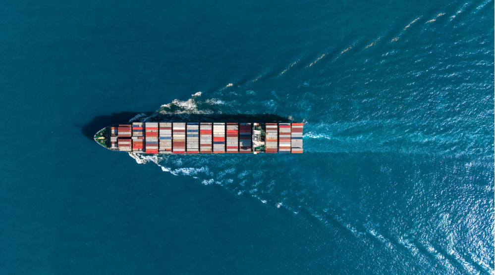 Portacontainer naviga nel mare blu visto dall’alto