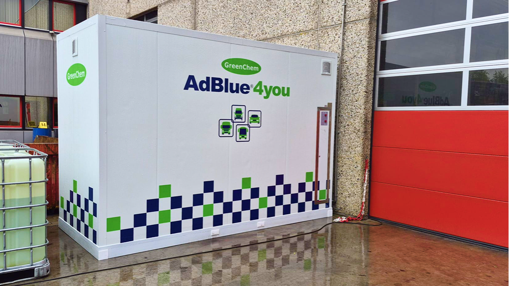 AdBlue opslagcontainer naast rood bedrijfsgebouw