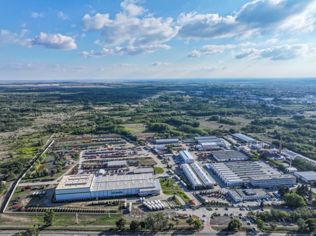 Aerial view of industrial complex beside green farmland